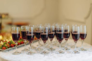 Bir sürü kırmızı şarap bir ziyafet masasında konukların eğlenmesi ya da yemek servisi için hazır.