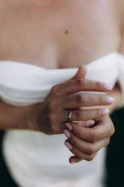 Gelin el ele tutuşmuş, parmağında altın bir alyans var. Evliliği, aşkı ve bağlılığı kutluyoruz