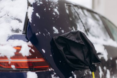 Karlı bir aracın korunması için şarj edilen elektrikli araba konnektörü, soğuk hava sorunlarını vurguluyor