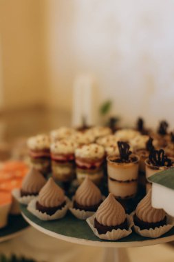 Katmanlı servis standında düzenlenen tatlı tatlı ve hamur işleri bir etkinlik ya da parti büfesinde konuklar için hazırdır.