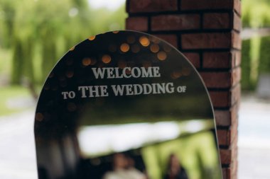 Yüzeyine yansıyan bokeh ışıkları olan düğün tabelası, evlilik törenini simgeliyor.