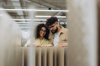 Mutlu çift birlikte karar veriyor, mağazadaki yeni ev yenileme projesi için malzeme seçiyor.