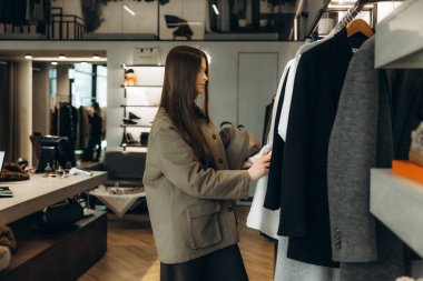 Modern bir perakende mağazasından yeni kıyafetler alan bir kadın. Tüketici harcamaları ve perakende terapi kavramı