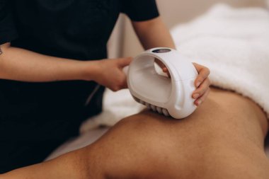 Eğitimli uzman, lenfatik drenaj ve deri gençleştirme için hastanın vücuduna estetik sonosferler terapi masajı yapıyor. Vücut ve sırt için endosphere masaj