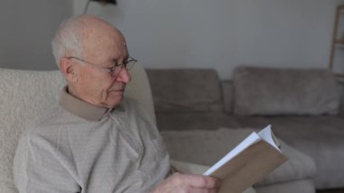 Kitap okurken koltukta dinlenen kıdemli bir adam. Kafkasyalı büyükbaba biraz edebiyatla emekliliğinin tadını çıkarıyor.