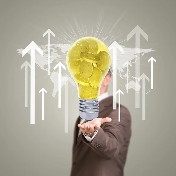 Businessman in a suit hold bulb with gold coins