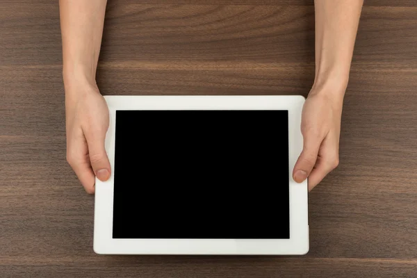 Humans hands holding white tablet