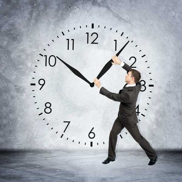 Businessman holding clock hand