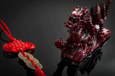 Zenginlik ve güç Fengshui sikke cazibesi ve Asyalı mistik ejderha tarafından sembolize ediliyor. Feng Shui, Çin felsefi sistemidir. Çevredeki herkesle uyum içindedir.