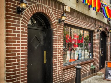 New York City, USA  - July 17, 2015: Gay pride flags are hanging outside the The Stonewall Inn in NYC clipart