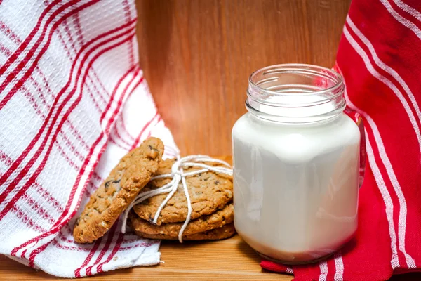 Sklenice mléka s soubory cookie ovesné vločky a rozinky — Stock fotografie