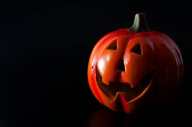 Cadılar Bayramı ve sonbahar ya da sonbahar tatili konsepti. Karanlık dramatik bir ışık altında korkunç bir kriko fener. Siyah üzerine izole edilmiş ve fotokopi alanı olan.