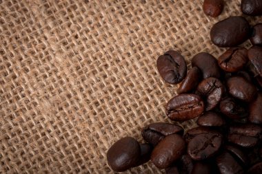 Kahve çekirdeklerinin yakın plan görüntüsü bir çuvala dökülmüş.