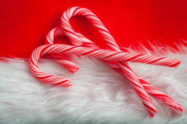Noel ve kış tatili konsepti. Kırmızı ve beyaz Noel Baba şapkalı baston şekerler. Şekerkamışı geleneksel Xmas tatlısıdır, esasen nane şekeri renginde iki renkli.