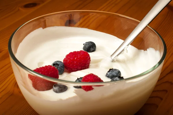 Bowl of yogurt with raspberries and blueberries — Stock Photo, Image