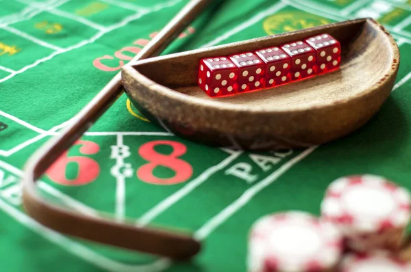 5 dobbelstenen in een kom en een stok op een craps tafel — Stockfoto