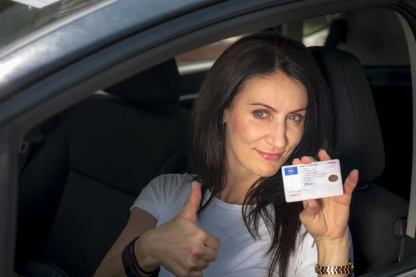 Woman in her late 30s to early 40s in a car happy to have passed the driver license test
