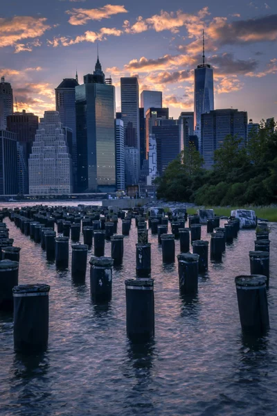 New York skyline seen from Brooklyn across the east river with some wooden pylons — Stockfoto