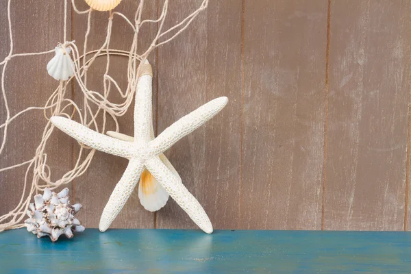 Estrella de mar y conchas de mar sobre tabla de madera —  Fotos de Stock