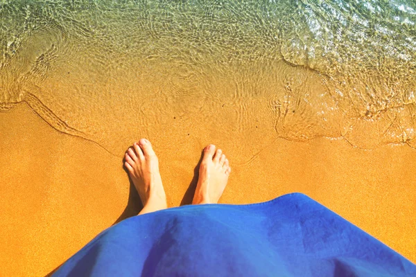 Женские ноги с морем — стоковое фото