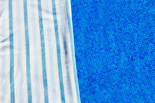 Полотенце и принадлежности для купания возле бассейна — стоковое фото