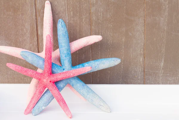 Red and blue starfish  on wooden board — Stock Photo, Image