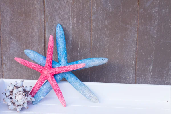 ahşap tahta üzerinde kırmızı ve mavi deniz yıldızı