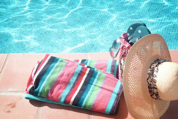 Toalha e acessórios de banho perto da piscina — Fotografia de Stock