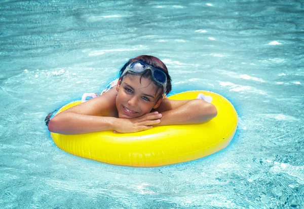 Ragazzo posa su anello di gomma in piscina — Foto Stock