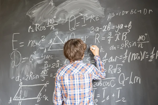 Ragazzo che scrive su lavagna nera — Foto Stock