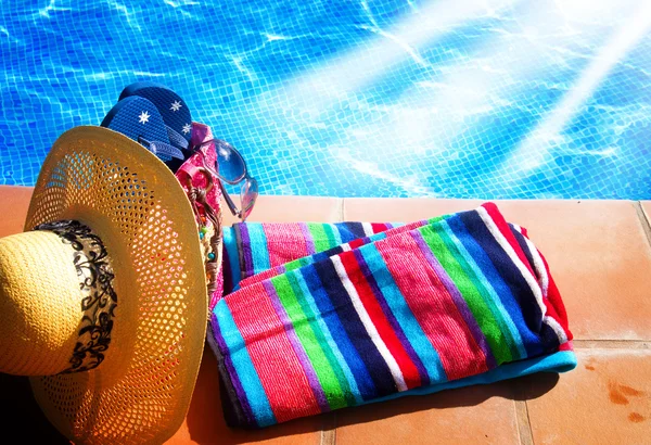 Towel and bathing accessories near pool — Stock Photo, Image