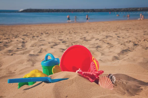 Balde com brinquedos de praia de plástico na areia — Fotografia de Stock