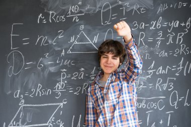 Kara tahtada yazan çocuk.