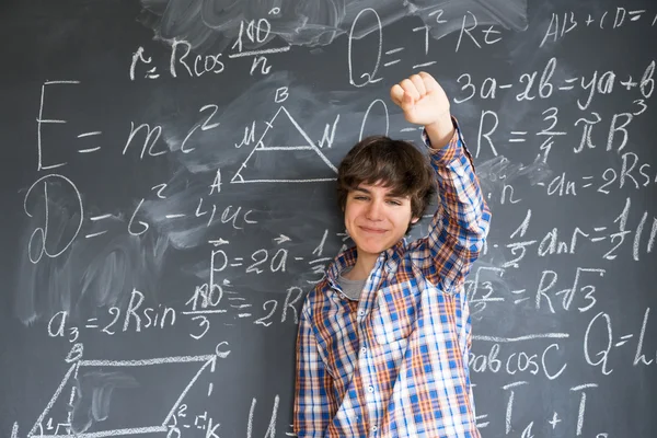 Boy writting on black board — Stok Foto