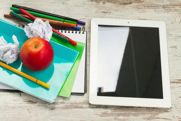 Mela con materiale scolastico — Foto Stock