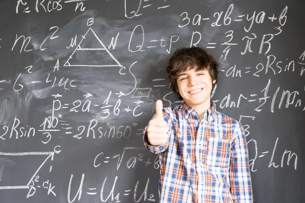 Boy writting on black board — Stok Foto