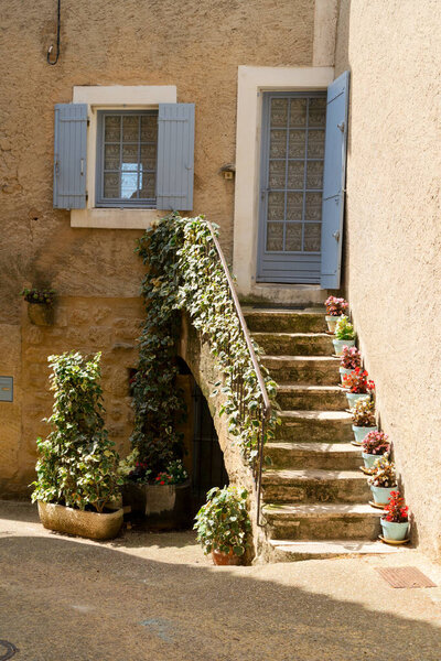 Beautiful old town street with stairs and flowers of Provence at summer day, France