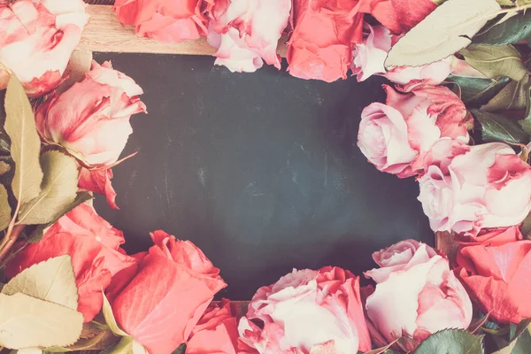 Рамка из красных и розовых роз на столе — стоковое фото