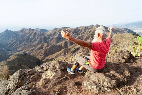 Hombre mayor saludando puesta de sol — Foto de Stock