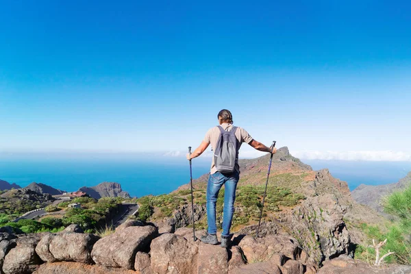 Heureux homme d'âge moyen voyageur en randonnée dans les montagnes, debout sur un rocher — Photo