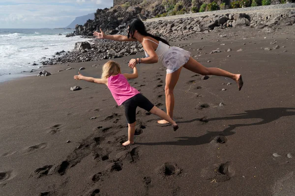 Healthy happy family mom and daughter doing stretching exercises on seaside — Stock Photo, Image