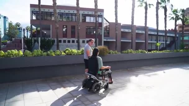 Tekerlekli sandalyedeki genç kadın erkek arkadaşıyla dışarıda buluşuyor. — Stok video