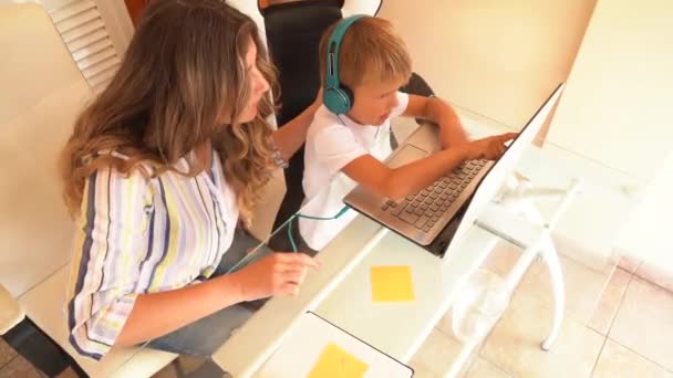 Мама работает дома с сыном — стоковое видео