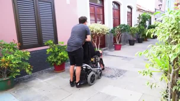 Młoda niepełnosprawna kobieta na wózku inwalidzkim randki z chłopakiem na świeżym powietrzu — Wideo stockowe