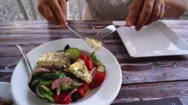 Birisi Yunan salatası yiyor.