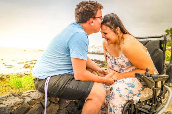 Femme handicapée en fauteuil roulant tenant la main de son petit ami tout en fréquentant à l'extérieur — Photo