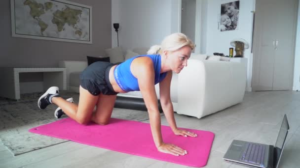 Sportif sarışın ince kadın evde online egzersiz yapıyor. — Stok video
