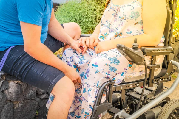 Femme handicapée en fauteuil roulant tenant la main de son petit ami tout en fréquentant à l'extérieur — Photo