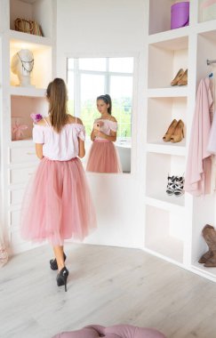 Tutu etekli ve yüksek topuklu ayakkabılı genç kız akıllı telefondan selfie çekiyor.