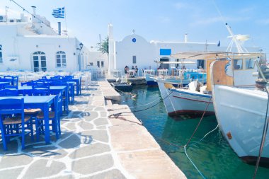 Gemi ve kafe masaları olan Naoussa köyü.